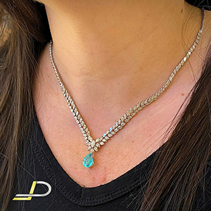 Gargantilha em ouro branco 18k, cravejada de brilhantes com lapidações em gotas e navetes com uma Turmalina Paraíba no centro pedra natural pendurada em formato de gota